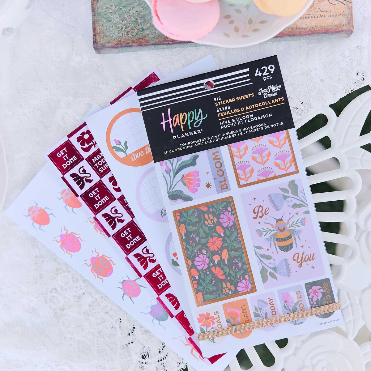 Hive & Bloom floral, bee and quote stickers arranged beside a white disc-bound planner
