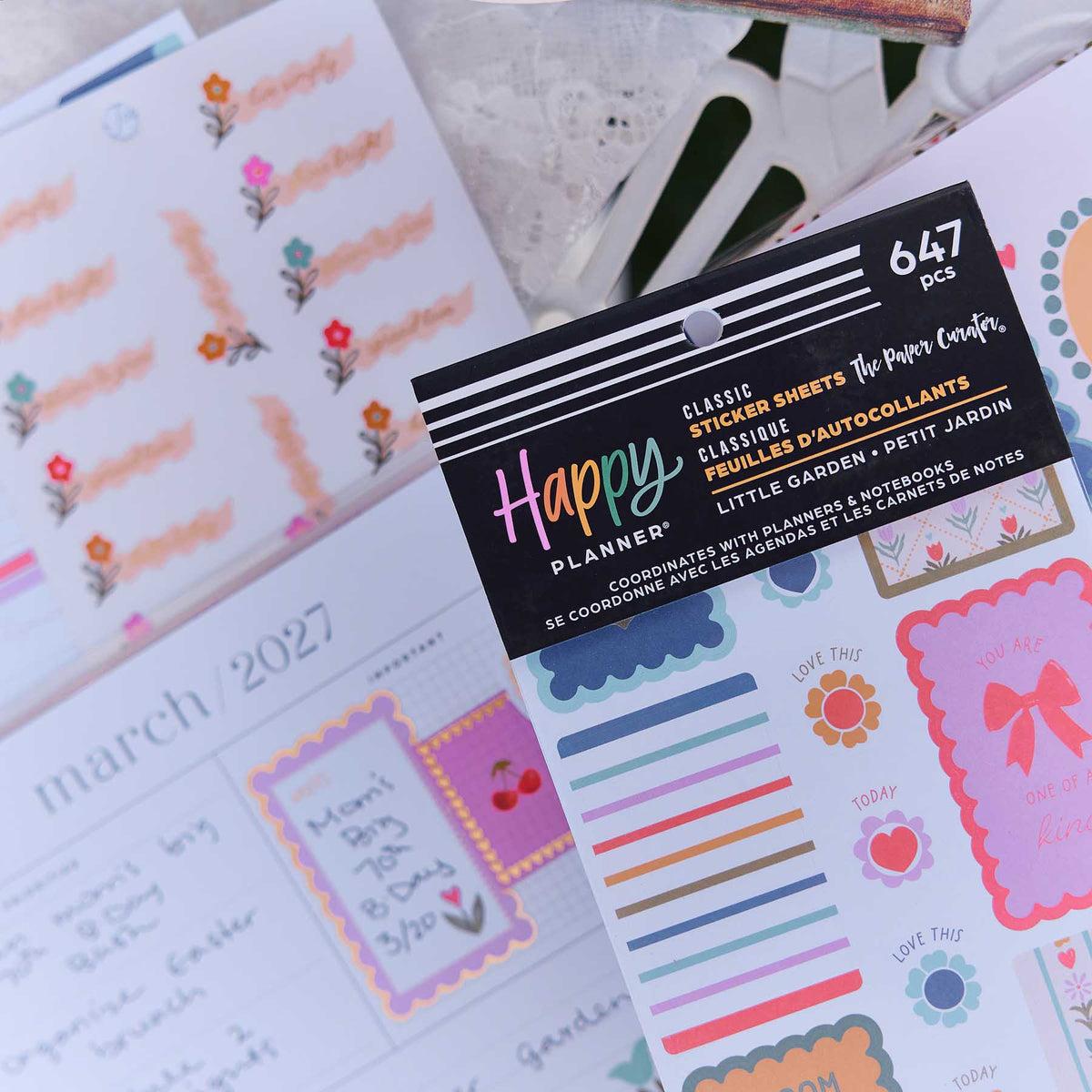 Close-up of Little Garden sticker book with The Paper Curator credit and floral sheets on a decorated planner