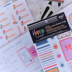 Close-up of Little Garden sticker book with The Paper Curator credit and floral sheets on a decorated planner