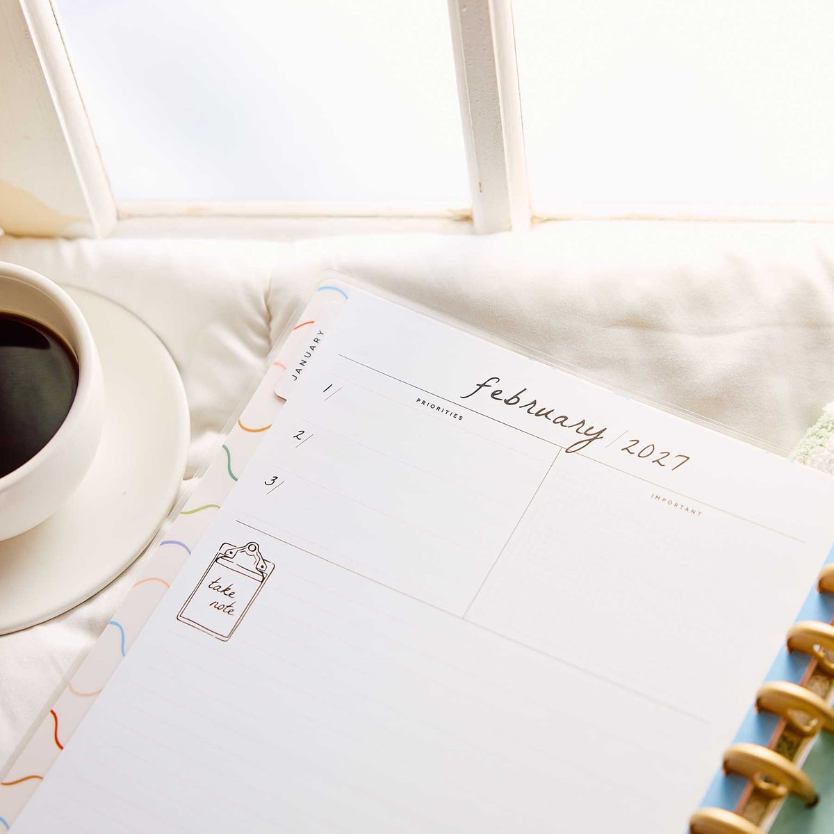 Pajama Plans Big planner February 2027 monthly calendar beside coffee