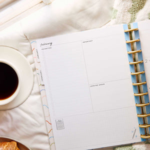 Happy Planner Pajama Plans February dashboard with priority sections beside coffee