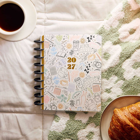 Happy Planner Pajama Plans Classic Horizontal Planner 2027: Sleep-themed cover beside coffee and a croissant
