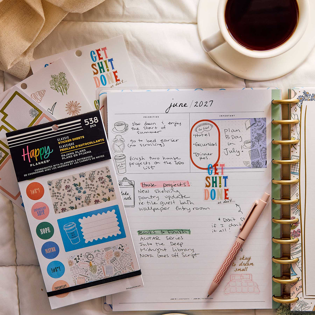 Happy Planner Pajama Plans sticker book beside a decorated weekly planner and cup of coffee on a bed