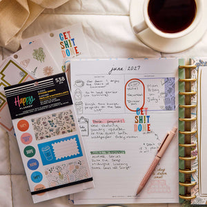 Happy Planner Pajama Plans sticker book beside a decorated weekly planner and cup of coffee on a bed