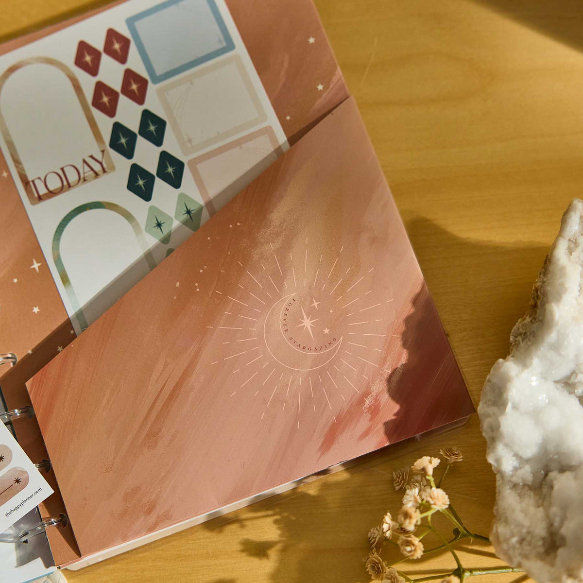 Starlit Glow celestial artwork and sticker sheets in a rose gold discbound planner