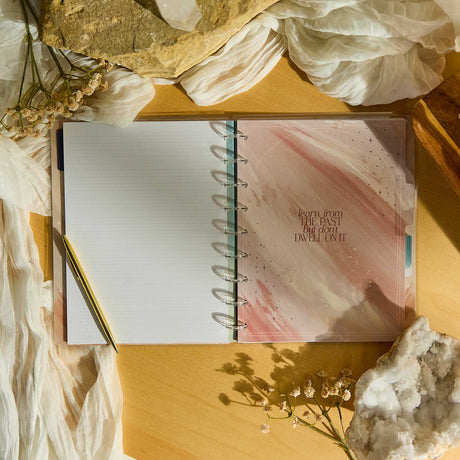 Open Starlit Glow notebook with a pink cover on a wooden surface