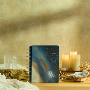 Starlit Glow planner blue starry cover beside candles and crystals