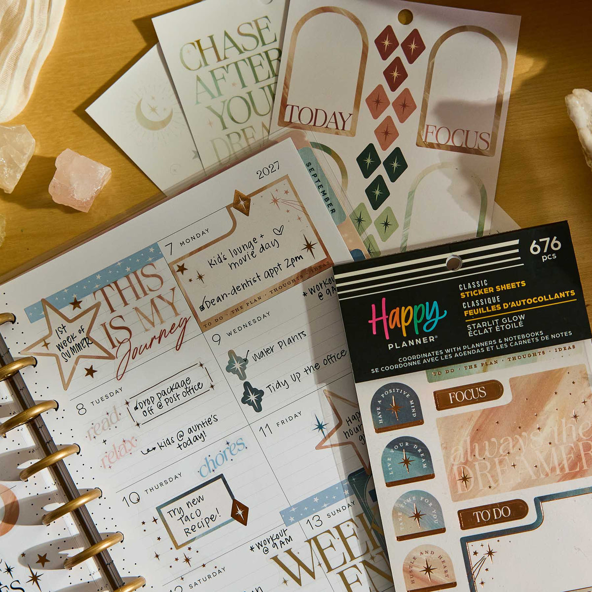 Starlit Glow celestial sticker sheets beside a decorated disc-bound planner