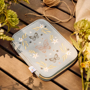 Blue corduroy Butterfly zip pouch with floral embroidery on a wooden table