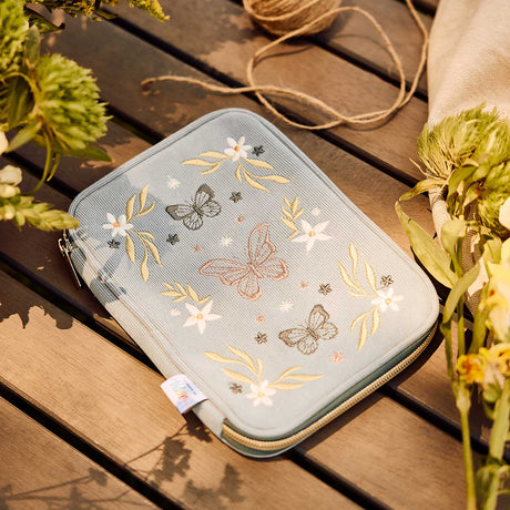 Blue corduroy Butterfly zip pouch with floral embroidery on a wooden table