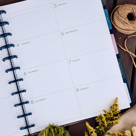 Happy Planner Wildflower Daydream dated lined pages and blue discs beside dried flowers