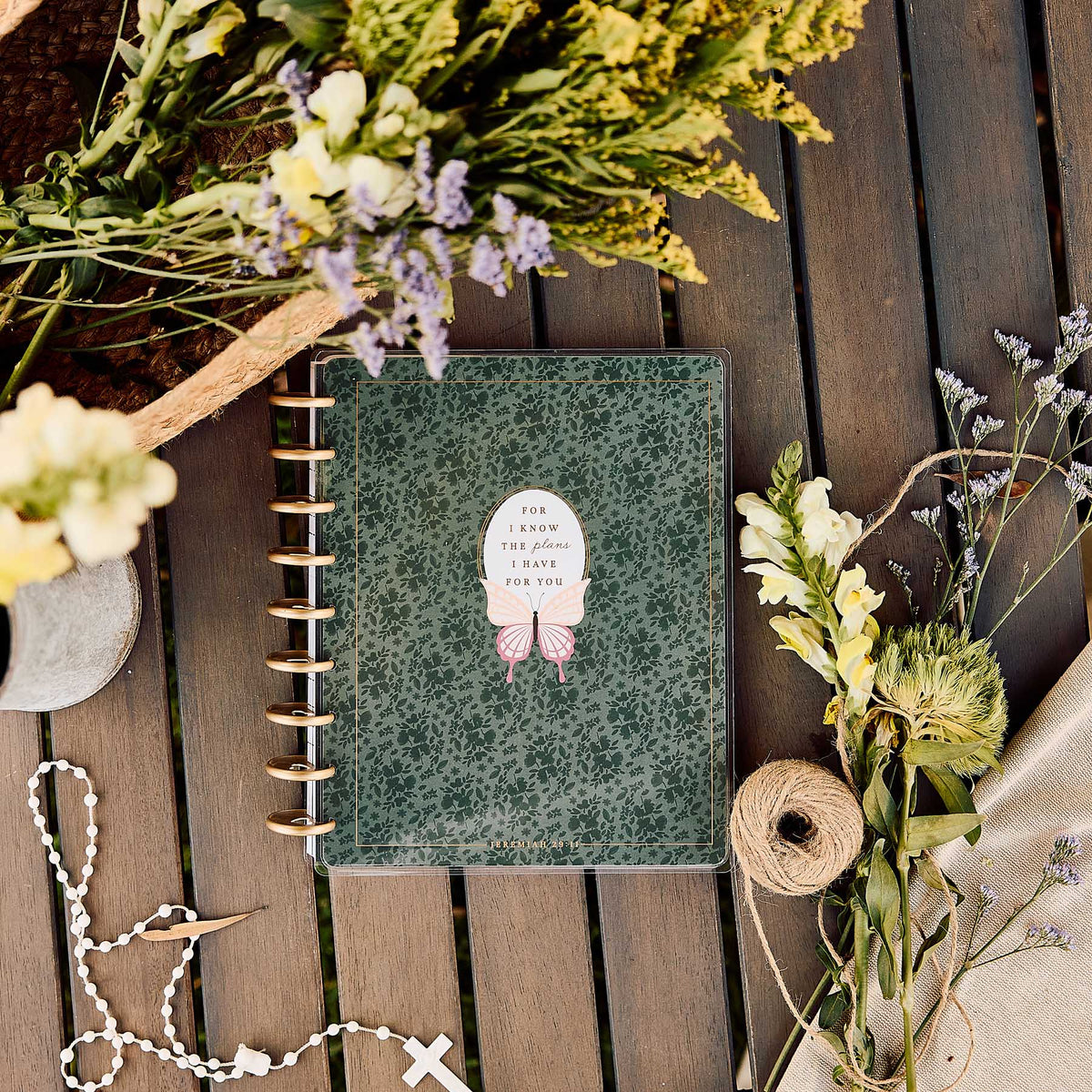 Wildflower Daydream green floral Faith Planner surrounded by dried flowers on a wooden table