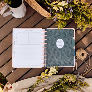 Wildflower Daydream planner open with floral cover beside flowers on a wooden table