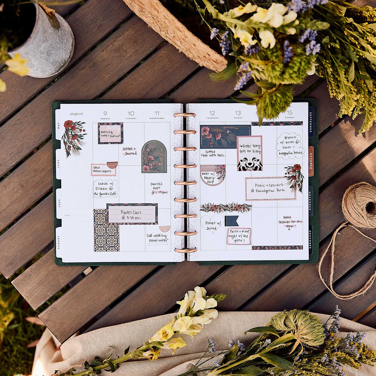 Twilight Tapestry planner open with floral stickers on a wooden table