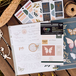 Wildflower Daydream Faith sticker book beside handwritten reflection pages, botanical stickers and a cross necklace