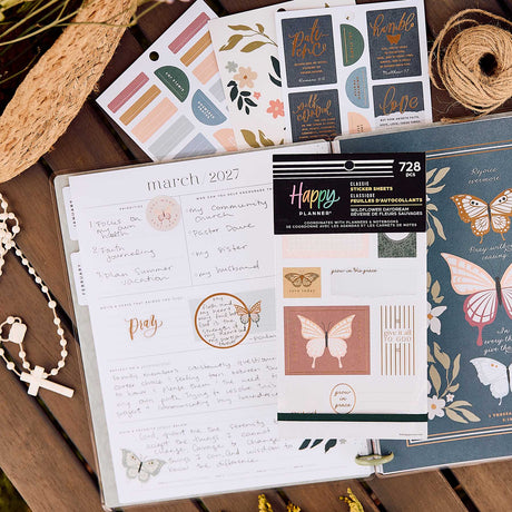 Wildflower Daydream Faith sticker book beside handwritten reflection pages, botanical stickers and a cross necklace