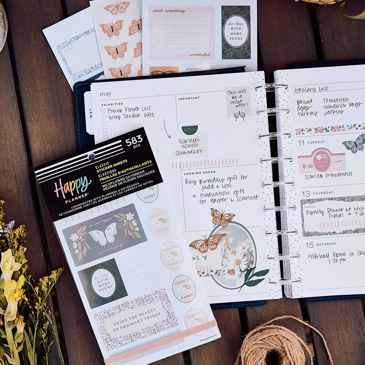 Wildflower Daydream sticker book beside an open disc-bound planner and coordinating butterfly sheets