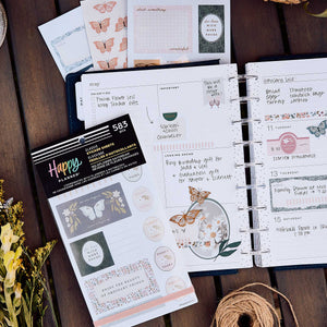 Wildflower Daydream sticker book beside an open disc-bound planner and coordinating butterfly sheets