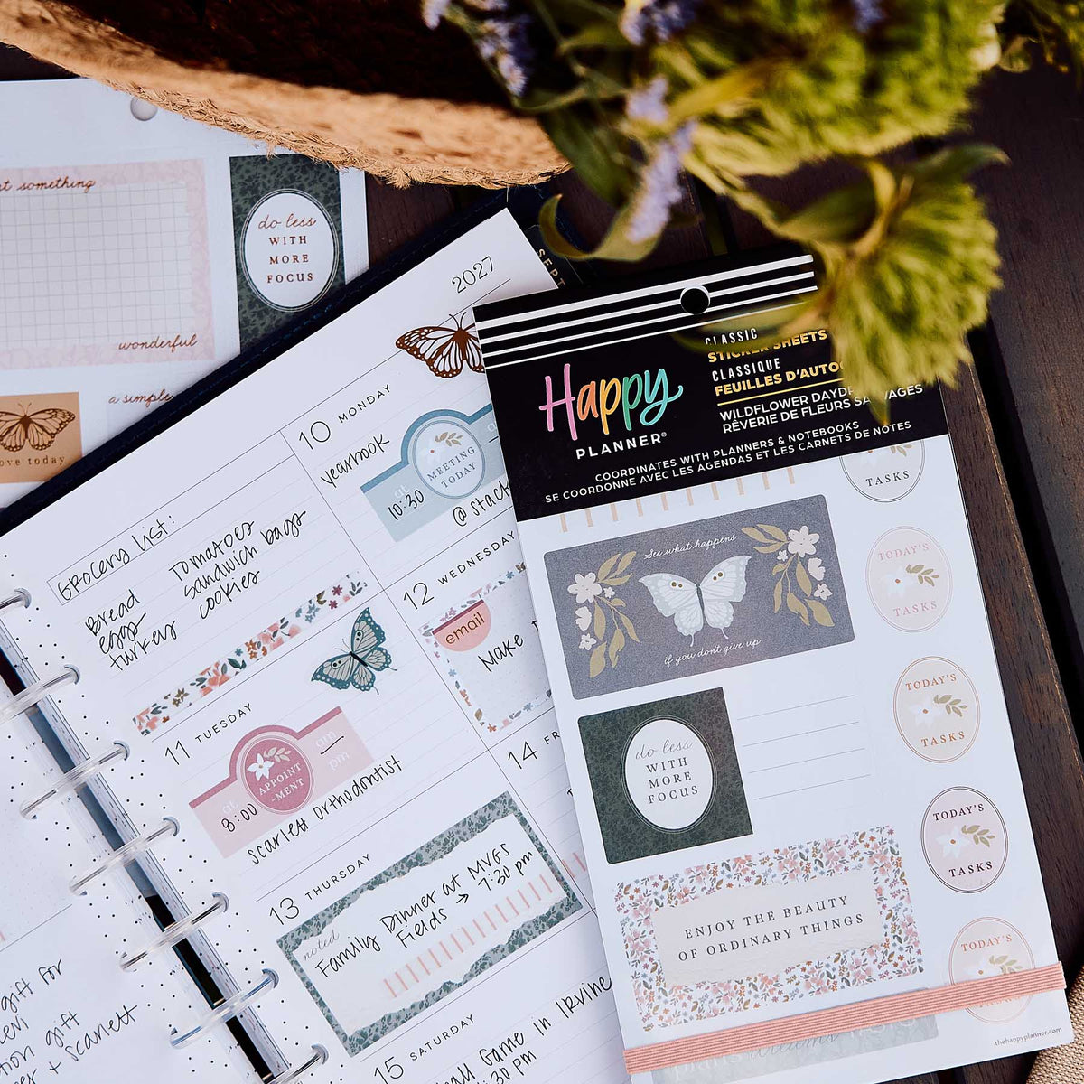 Wildflower Daydream sticker book beside a weekly planner with handwritten plans and floral labels