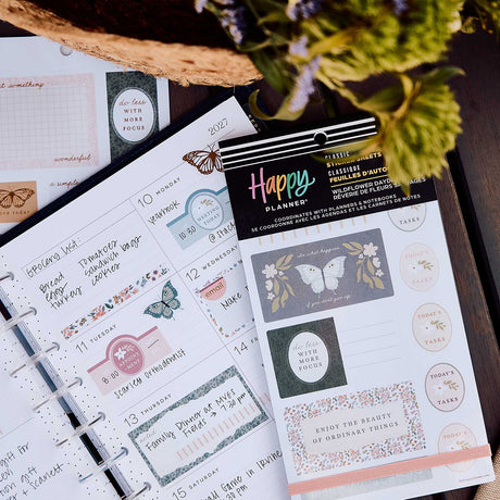 Wildflower Daydream sticker book beside a weekly planner with handwritten plans and floral labels