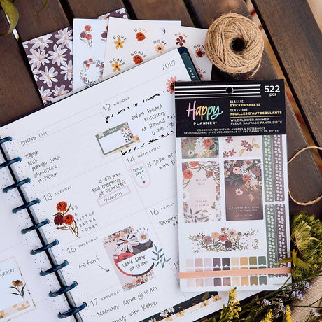 Wildflower Whimsy sticker book and floral sheets beside an open disc-bound planner decorated with flowers and labels