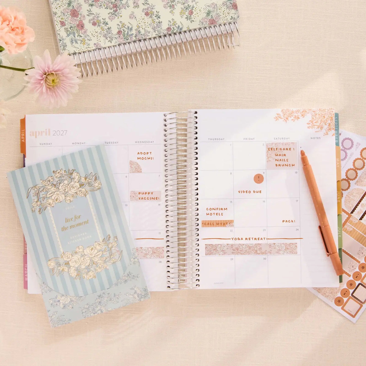 Erin Condren sticker book: Toile sticker book beside an open horizontal planner