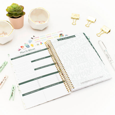 Open planner with a to-do list on a white surface with decorative items.