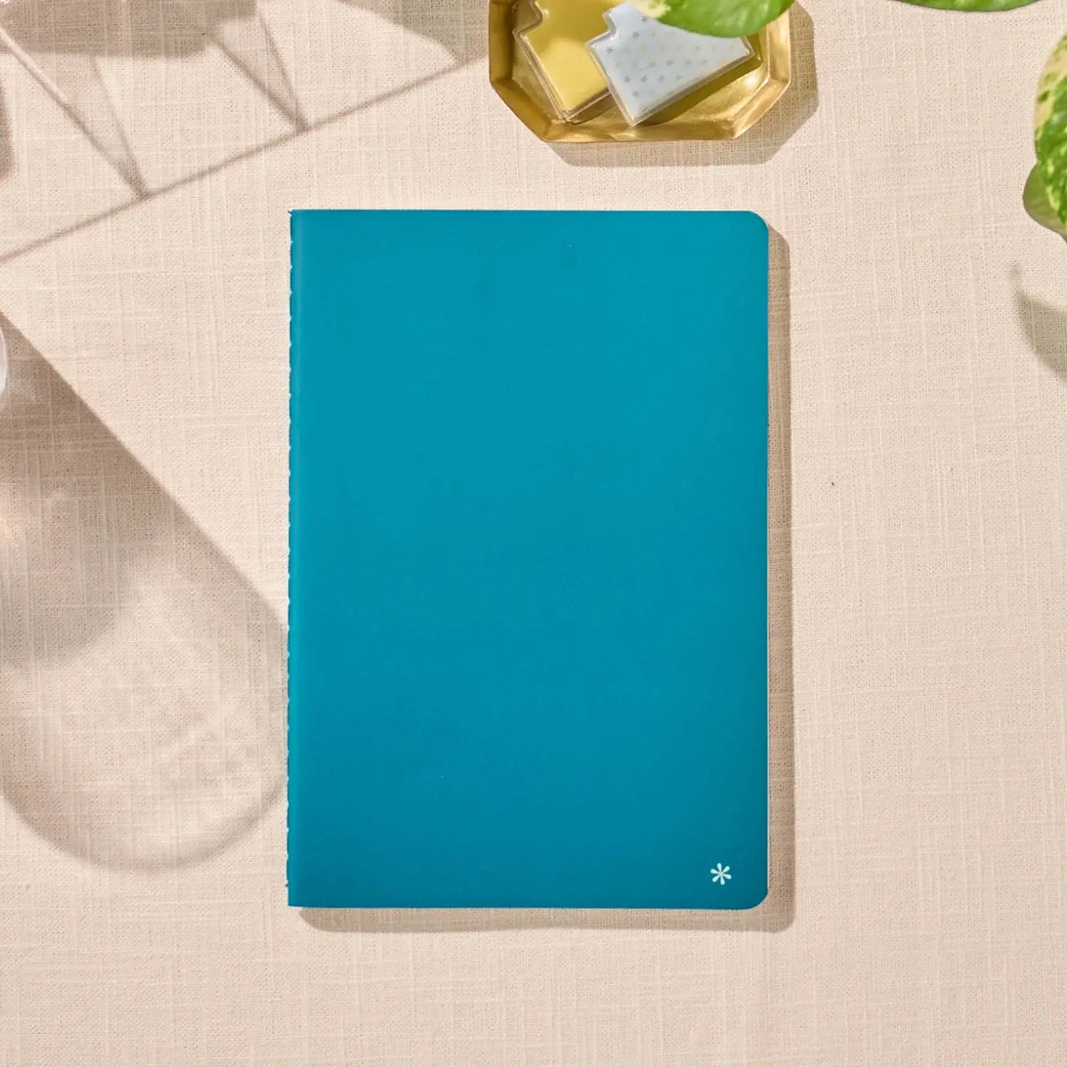 Erin Condren Petite Journal: Closed Peacock journal on a desk