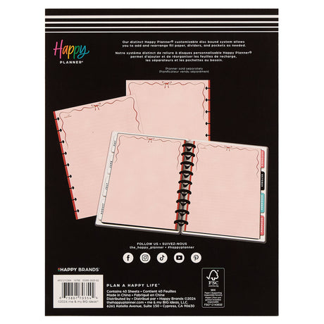 Happy Planner customizable discbound system packaging with pink cover and black binding on a black background.