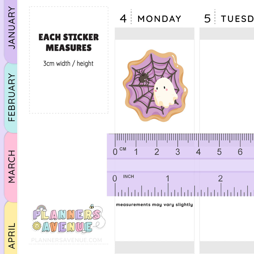 Halloween-themed sticker with spider and spiderweb design on a planner page with ruler for scale.