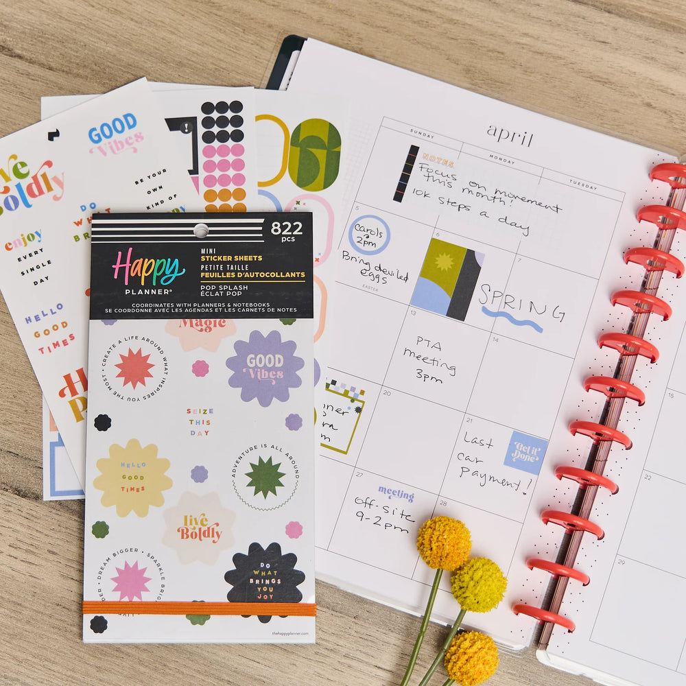 Happy Planner Pop Splash Mini stickers and flowers on a wooden surface