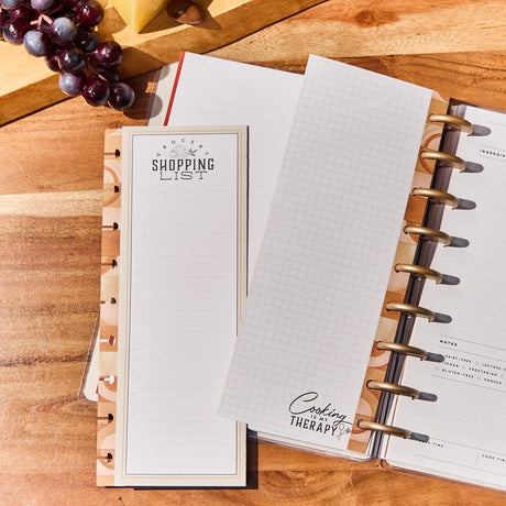 Open planner with a shopping list on a wooden surface