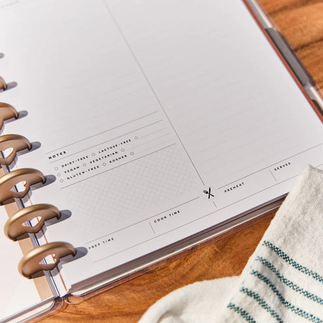 Open planner with disc binding on a wooden surface