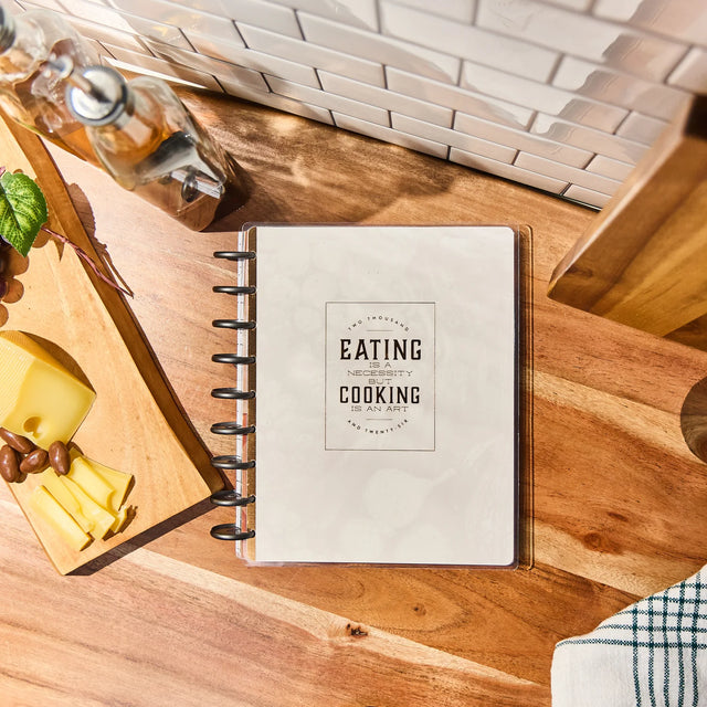 Meal Planner titled 'Eating & Cooking' on a wooden surface with kitchen items.