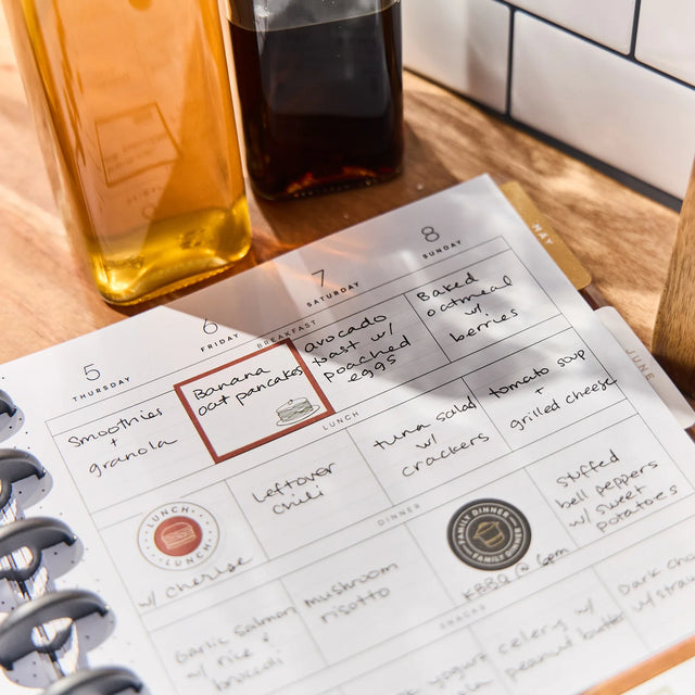 Daily planner with meal planning notes on a wooden table