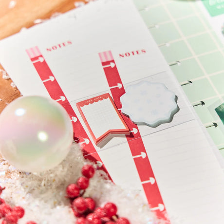 Notebook with red and white design on a textured surface with berries and a bubble.