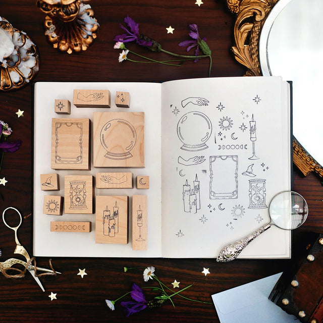 Practical Magic Stamp Set of wooden stamps and illustrations on a dark surface with decorative items.