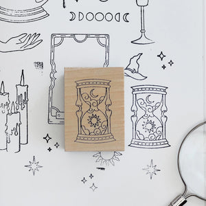 Rubber stamp with hourglass design on a white background with black line art illustrations.
