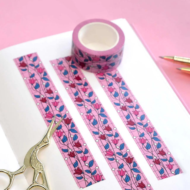 Pink floral tape with strips and scissors on a pink background