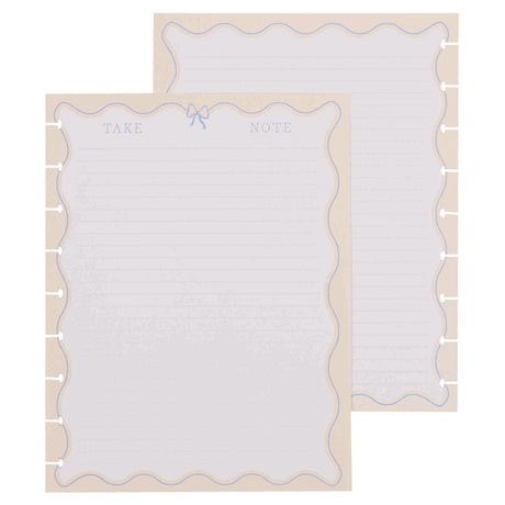 Two white notepads with decorative borders on a beige background