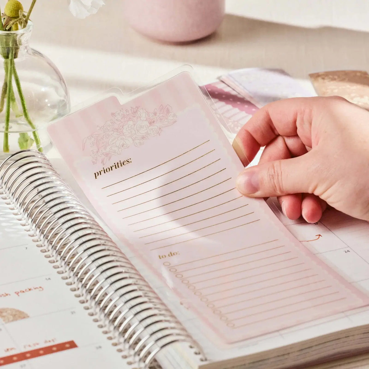 Erin Condren snap-in dashboard: Hand positioning the dashboard inside a coiled planner