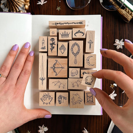 Fantasy & Fiction Stamp Set with various designs held by a person on a white surface.