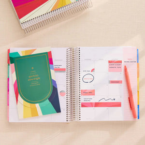 Erin Condren sticker book: Sticker book beside an open horizontal planner